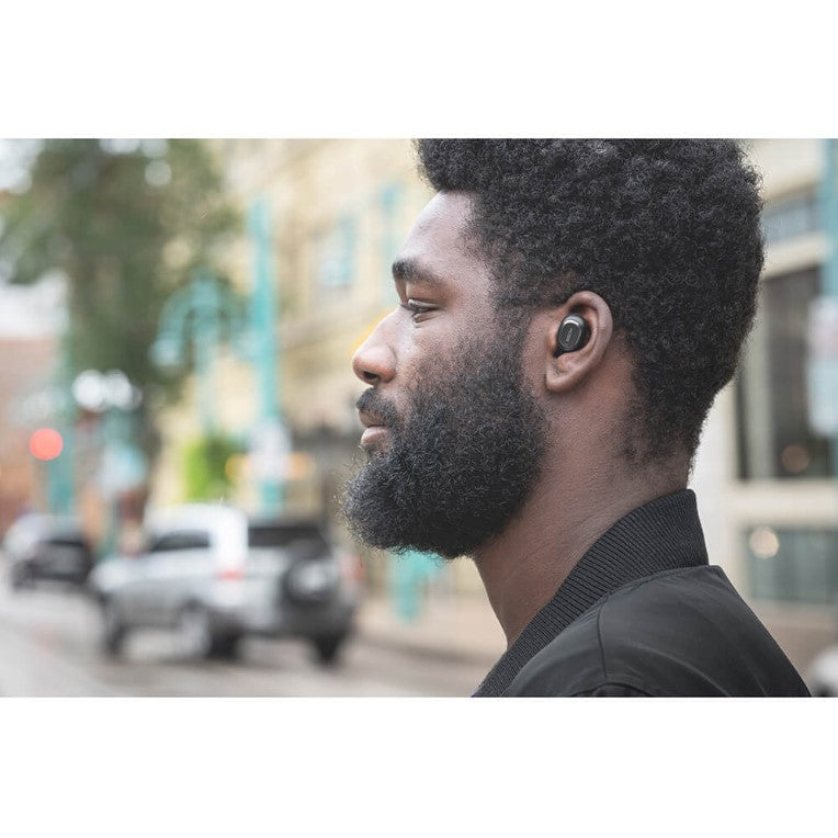 Skäggig mörkhyad man med Koss in ear hörlurar