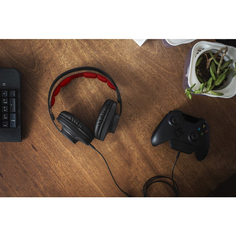 Koss gaming headset som ligger på ett träbord jämte en Xbox dosa