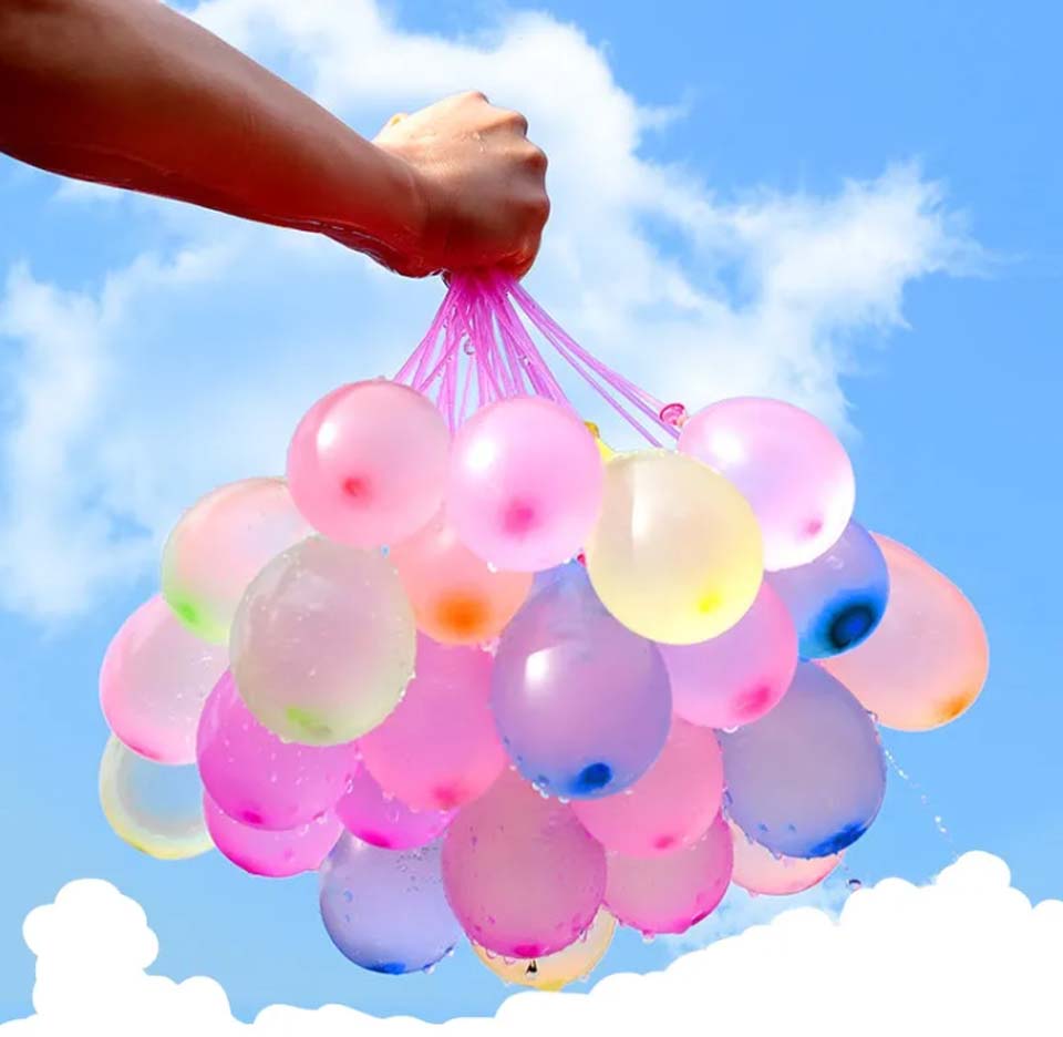 Person håller upp ett kluster av snabbfyllda vattenballonger, bakgrund himmel med moln
